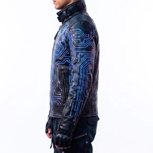 May include: A black leather jacket featuring a vibrant blue circuit board pattern printed across the chest and sleeves. The jacket includes a high collar with a buckle strap, zippered pockets, and quilted shoulder detailing for a structured look.