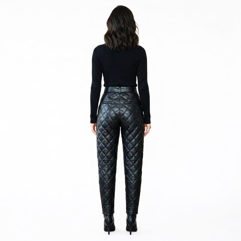 May include: A black long-sleeved top paired with high-waisted black trousers featuring a quilted diamond pattern. The trousers have a structured waistband, two back pockets, and a tapered leg silhouette, ending in black pointed-toe high heels.