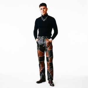 May include: A black long-sleeved turtleneck sweater paired with trousers featuring a patchwork design of black and brown leather panels. The pants are accented with visible light-colored stitching along the seams and are worn with a black belt.