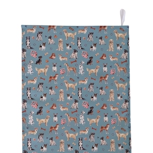 Könnte beinhalten: Ein blaues Küchentuch mit einem sich wiederholenden Muster verschiedener Hunderassen, Knochen und Pfotenabdrücken. Das Tuch hat eine weiße Schlaufe zum Aufhängen. Die Hunde sind in verschiedenen Posen und Farben dargestellt.