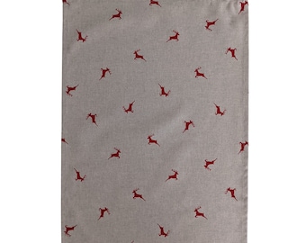 May include: A rectangular beige kitchen towel with a repeating pattern of red reindeer silhouettes. The towel has a loop for hanging at the top and is made of a woven fabric.