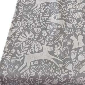 May include: Grey and white fabric with a repeating pattern of stylised animals, plants, and flowers. The pattern includes deer, rabbits, squirrels, and various floral motifs.