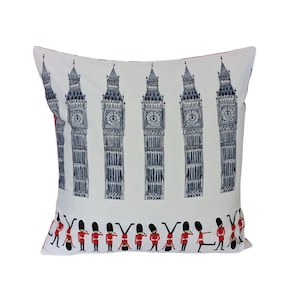 May include: White cushion with a repeating pattern of Big Ben and red and blue guards. The cushion is approximately 40 cm by 40 cm.