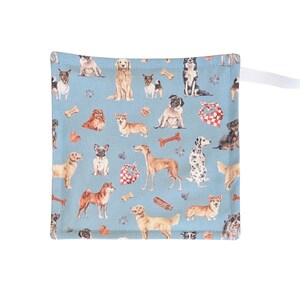 May include: Square, pale blue fabric featuring a pattern of different dog breeds, bones, and bandanas. A white ribbon is attached to the top right corner. The fabric is likely cotton or a similar material.