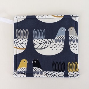 May include: A blue fabric pot holder with a white background featuring a pattern of stylised birds and leaves. The birds are in shades of blue, grey, and yellow.