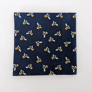 May include: A dark blue fabric with a repeating pattern of yellow and black bees. The fabric is square in shape and has a subtle texture.