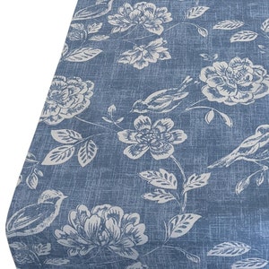 May include: Blue fabric with a white floral and bird pattern. The fabric has a textured, linen-like appearance.