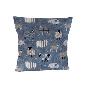 May include: A blue throw pillow with a pattern of sheep in various colors and patterns. The sheep are on a light blue background with white dots.