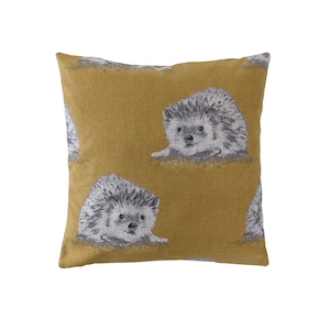 May include: A mustard yellow throw pillow with a repeating pattern of gray and white hedgehogs.