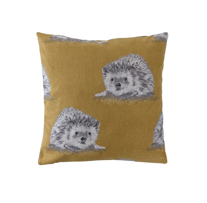 May include: A mustard yellow throw pillow with a repeating pattern of gray and white hedgehogs.