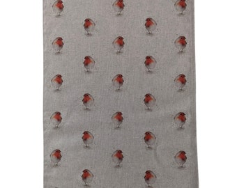 May include: A gray tea towel with a repeating pattern of red robins. The robins are depicted in a watercolor style.