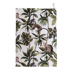 Pode incluir: Uma toalha de cozinha branca com um padrão de macacos marrons balançando em palmeiras com folhas verdes sobre um fundo branco.