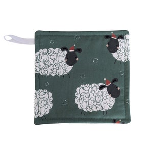 May include: Square, dark green pot holder with a white hanging loop. The pot holder features a repeating pattern of white sheep with black faces and red Santa hats. The sheep have curly wool against a dark green background.