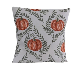 May include: Square decorative pillow with a repeating pattern of orange pumpkins and green leafy vines on a light gray background. The pillow is a seasonal home decor item, perfect for fall.