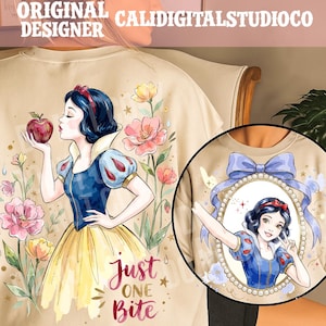 May include: A beige t-shirt featuring a graphic of Snow White holding a red apple surrounded by pink and yellow flowers with the text Just One Bite. A circular inset shows Snow White inside an oval frame with a blue bow and pearl border.