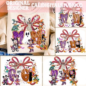 May include: A light-colored sweatshirt featuring a graphic print of cartoon characters in Halloween costumes, including a mummy, a ghost, and a witch, arranged around the word MOM or GAGI with a large striped bow and spiderweb accents.