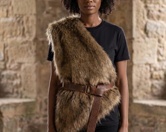 May include: A brown faux fur shoulder wrap worn over a black t-shirt and black pants, secured at the waist with a brown leather belt featuring an embossed knotwork pattern and a metal ring buckle, creating a layered and textured appearance.