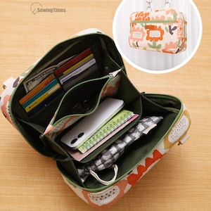 May include: A rectangular crossbody bag with a cream, orange, and green floral pattern. The bag is open, revealing an olive green interior with multiple compartments, card slots, a smartphone, a notebook, and a small grey patterned pouch.