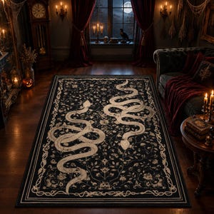 Puede incluir: Una alfombra rectangular con fondo negro y un intrincado patrón botánico blanco de enredaderas y flores. Dos grandes serpientes blancas estilizadas aparecen representadas en una posición sinuosa y simétrica en el centro de la alfombra.