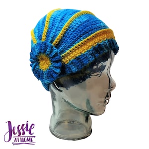 May include: A blue and yellow crocheted hat with a flower design. The hat is on a mannequin head.