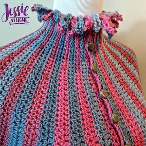 May include: A close-up of a crocheted garment with a ruffled collar and a striped pattern in shades of pink and blue. The garment has a button closure and features decorative buttons.