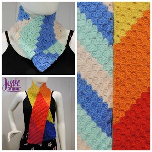 Puede incluir: Una bufanda de crochet colorida con un patrón de arcoíris. La bufanda está hecha con diferentes tonos de hilo azul, verde, amarillo, naranja y rojo. La bufanda se muestra siendo usada por un maniquí.