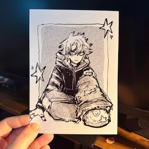 May include: A black and white ink illustration on a rectangular card featuring a stylized anime character with spiky hair wearing a hooded jacket and baggy pants. The character is sitting down, surrounded by hand-drawn stars and a dotted background.
