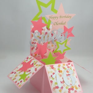 May include: A pink pop-up birthday card with star cutouts in pink and green. The card features the word "Sweet" and the number "16" in silver, along with the text "Happy Birthday Olenka!" on a star.