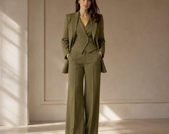 May include: An olive green three-piece suit consisting of a tailored blazer, a double-breasted vest with buttons, and wide-leg trousers. The ensemble features a consistent solid olive green color throughout, with structured shoulders and clean lines.
