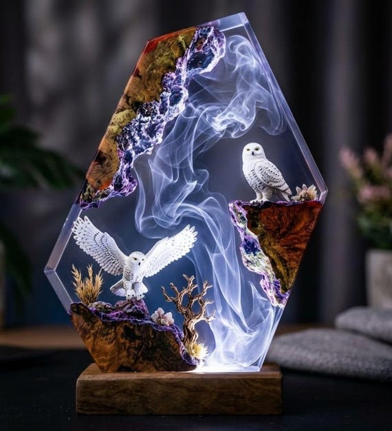 A snowy owl preserved in glowing epoxy resin — part diorama, part desk lamp, with the kind of wildlife detail that makes it feel like a naturalist's artifact.