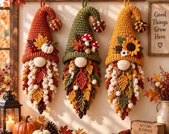 May include: Three hanging crochet gnome decorations in orange, green, and yellow. Each gnome features a pointed hat adorned with autumn elements like pumpkins, mushrooms, and sunflowers, and a long beard made of textured crochet leaves.