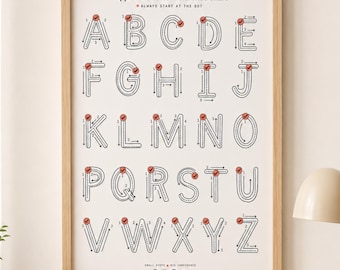 Könnte beinhalten: Ein Lernposter mit dem Titel Uppercase Letter Reference Chart in einem hellen Holzrahmen. Es zeigt das Alphabet mit gestrichelten Buchstaben, nummerierten Strichfolgen und roten Punkten als Startmarkierung. Unten steht der Text Daily Dots.