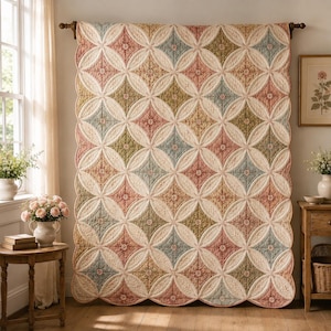 May include: A large rectangular quilt featuring a repeating pattern of cream-colored circles intersecting to form diamond shapes. The diamonds are filled with floral prints in muted shades of dusty pink, sage green, and soft blue, with scalloped edges.