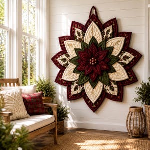 Puede incluir: Un gran tapiz acolchado en forma de estrella con un diseño de flor de pascua en capas. Los pétalos de tela alternan entre rojo intenso, verde bosque y crema con costuras intrincadas y pequeñas cuentas decorativas de color dorado.