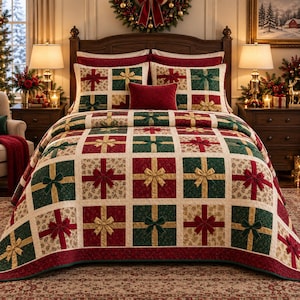 Op de afbeelding: Een quiltset met een rasterpatroon van rode, donkergroene en crèmekleurige vierkanten, elk versierd met een driedimensionale stoffen strik. Het ontwerp bootst ingepakte cadeautjes na, aangevuld met twee bijpassende kussenslopen en een rood sierkussen.