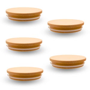 May include: Five circular light brown wooden lids arranged in a staggered pattern. Each lid features a smooth, flat top surface and a clear, flexible silicone gasket ring attached to the underside for a secure fit on containers or jars.