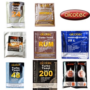 Puede incluir: Una colección de nueve paquetes de levadura turbo y agente clarificante de la marca Alcotec en varios colores, incluyendo plata, marrón, azul y negro. Cada sobre rectangular presenta el logotipo de Alcotec, nombres de productos y texto.