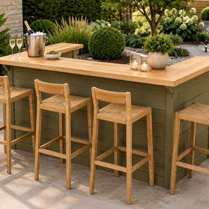 May include: An L-shaped outdoor bar with a sage green horizontal plank base and a natural light wood countertop. Four tall wooden bar stools with woven seats are arranged around the bar. A metal ice bucket with a bottle and two glasses sit on top.