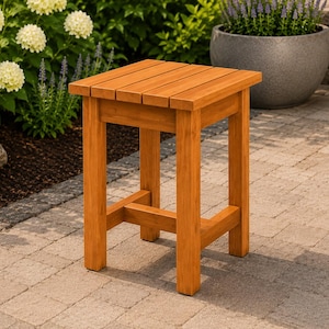 May include: A square wooden stool with a slatted top surface and four straight legs connected by a lower support frame. The stool features a warm, natural brown wood grain finish and a sturdy construction with visible horizontal slats on the seat.