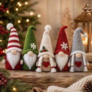 May include: Five crocheted gnome figurines with tall pointed hats, white yarn beards, and round noses. The gnomes feature red, green, cream, and gray colors, with decorative elements including white snowflakes, a red heart, and holly leaves.