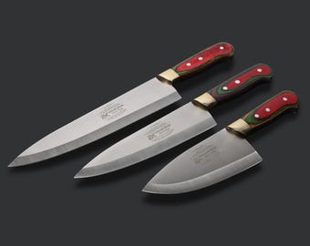 May include: A set of three stainless steel kitchen knives with silver blades and multi-colored handles in red, green, and purple. Each blade features a metallic bolster and is stamped with the text Stainless Steel Premium Quality.