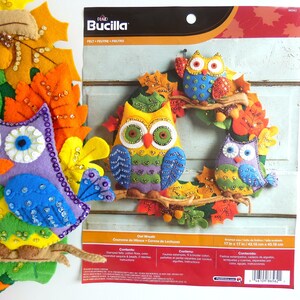 May include: A felt craft kit to make an owl wreath. The kit includes felt pieces, beads, and instructions. The finished wreath is 17 inches by 17 inches.