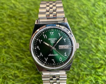 Orologio da polso automatico vintage Seiko 5 da uomo con quadrante verde, datario e cinturino in acciaio inossidabile.
