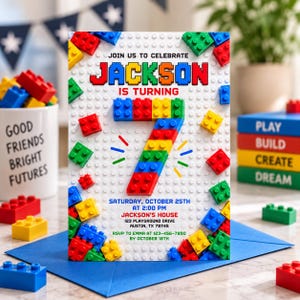 May include: A birthday invitation card featuring a white background with a raised plastic brick texture. The text reads: JOIN US TO CELEBRATE JACKSON IS TURNING 7. The number 7 is constructed from colorful plastic bricks. Includes event details.