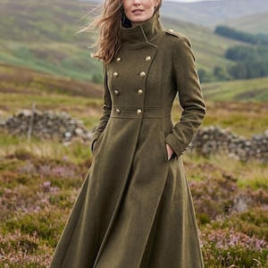 May include: An olive green long coat featuring a high collar, a double-breasted front with gold-toned buttons, epaulets on the shoulders, and a flared skirt silhouette. The coat includes side pockets and long sleeves with buttoned cuffs.