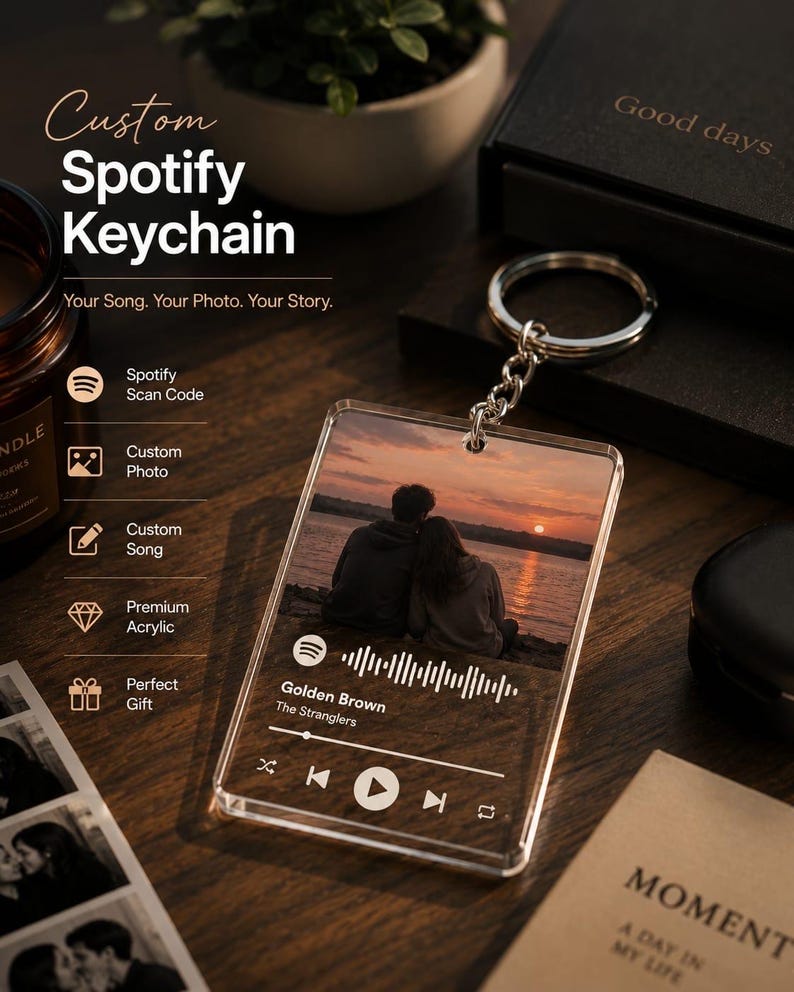May include: A rectangular clear acrylic keyring featuring a printed photograph of two people sitting by a lake at sunset. The keyring displays a white Spotify scan code, the song title Golden Brown by The Stranglers, and playback control icons.