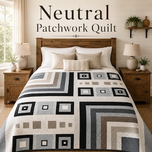 May include: A patchwork quilt featuring a geometric pattern of squares and rectangles in shades of black, grey, beige, and white. The quilt is displayed on a bed with white pillows and a small rectangular accent pillow. Text reads Neutral Patchwork Quilt.