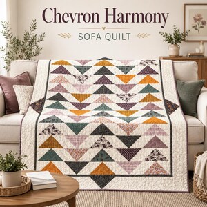 Puede incluir: Una colcha para sofá con un patrón de chevrón repetitivo hecho de parches de tela triangulares en tonos amarillo mostaza, gris oscuro, verde apagado, rosa viejo y estampados florales sobre un fondo de color crema.