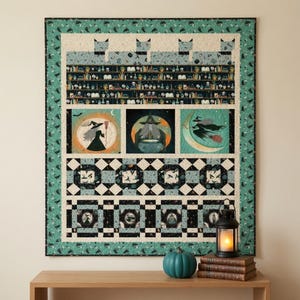 Könnte beinhalten: Ein rechteckiger Quilt mit einem blaugrünen Rand und einem wiederkehrenden Katzenmuster. Das Design zeigt Regale voller Zaubertrankflaschen, drei zentrale Felder mit Hexenmotiven und untere Bereiche mit schwarz-weißen geometrischen Mustern.