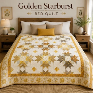 Op de afbeelding: Een bedsprei met een herhalend sterrenpatroon in goudgeel, mosterdgeel en wit. De sprei heeft een brede rand met een bloemen- en bladerprint en ligt op een bed met twee witte kussens, twee beige kussens en een mosterdgeel lendenkussen.